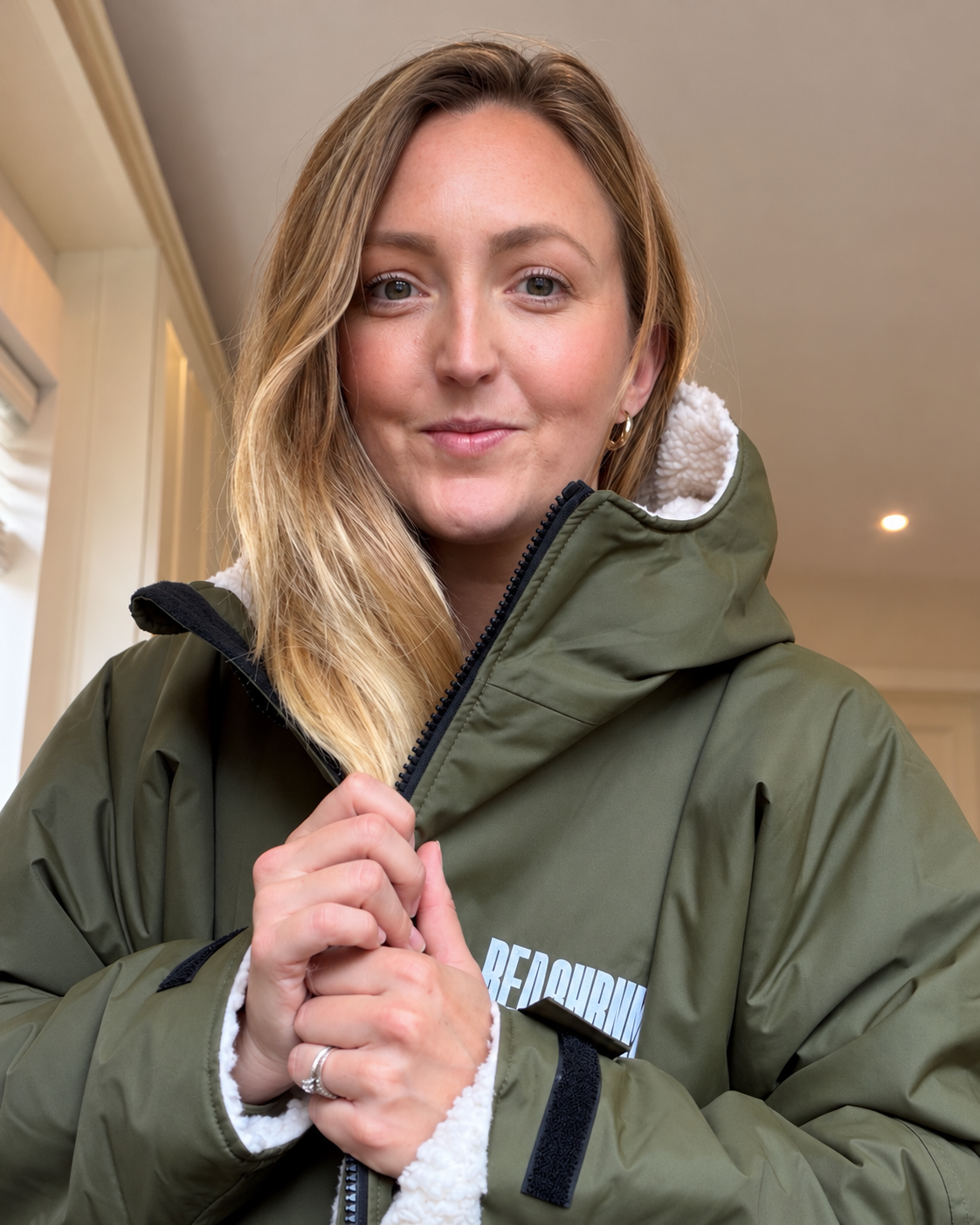 Sarah Honeybun wearing an olive green outdoor coat
